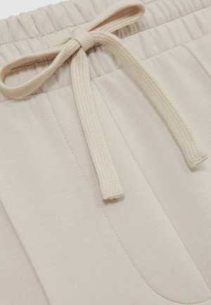 Beige Baumwoll-Sweatpants mit weicher Textur, ausgestattet mit einem Kordelzugbund und seitlichen Taschen. Glattes Material mit dezenten Nähten.