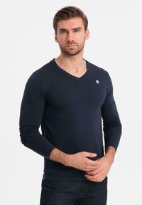 Námorně modré tričko s dlouhým rukávem a výstřihem do V vyrobené z jemné bavlny, s malým logem na hrudi a přiléhavým střihem na manžetách a lemu.