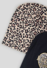Czarna koszulka z leopardzim nadrukiem na rękawie w beżowym kolorze z czarnymi i brązowymi plamkami; zawiera złoty brokatowy akcent z napisem "WIERZ".