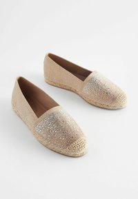 Espadriller i beige med metallisk nettingoverdel, rund tå og vevd jutebunn. Teksturert finish med skinnende aksenter langs toppen.