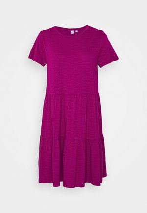 Růžová šaty s krátkým rukávem a délku po kolena, kulatým výstřihem a vrstvenou sukní, vystavené na bílém pozadí.