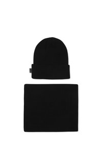 Bonnet en tricot côtelé noir et cache-cou assorti, tous deux dotés d'une texture douce et d'un design sans couture, adaptés à un port par temps froid.