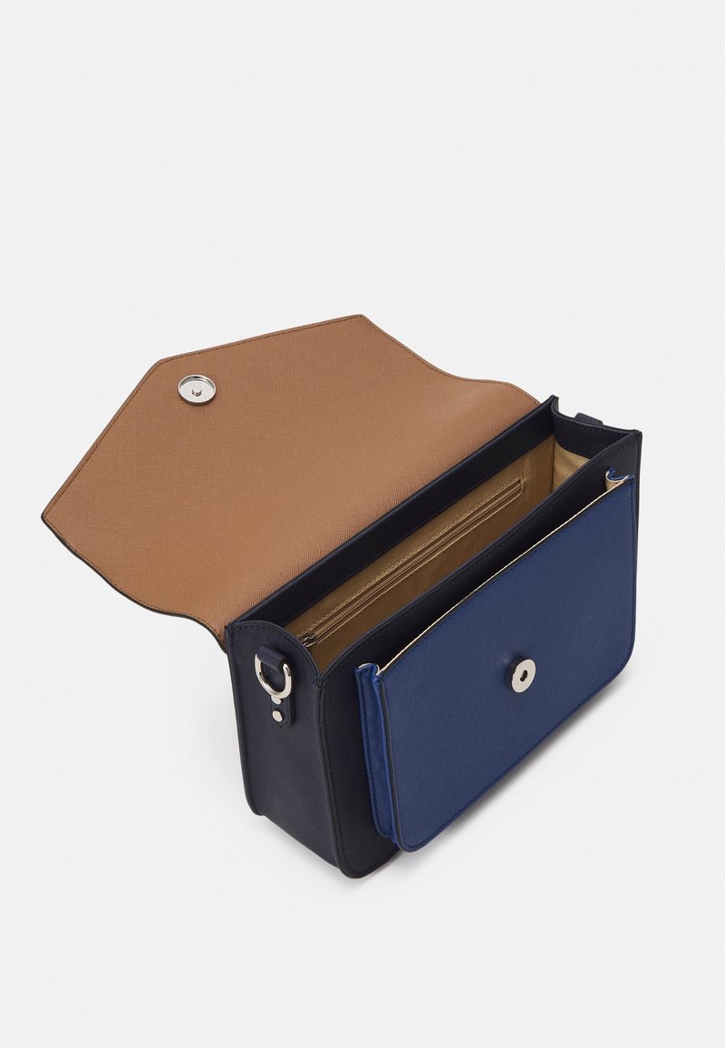 Petit sac à main rectangulaire bleu marine et noir avec intérieur beige, rabat ouvert, bouton magnétique argenté et poche intérieure zippée.