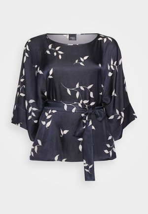 Sötétkék selyem blúz fehér levél mintával, széles ujjak, és derékon megkötős öv. Puha textúra és laza szabás.