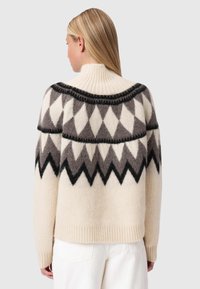 Κρέμα πουλόβερ με μαύρο και γκρι σχέδιο ζιγκ-ζαγκ, ριμπ κολάρο και μανσέτες, απαλό υλικό και χαλαρή εφαρμογή, θέα από πίσω.