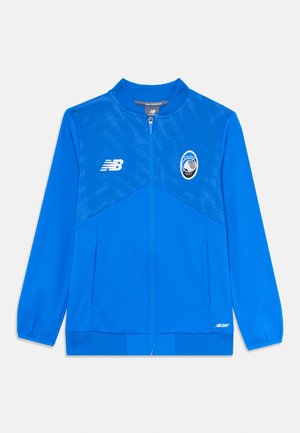Giacca zip-up blu New Balance con parte superiore perforata, logo Atalanta 1907 a destra, logo New Balance a sinistra e tasche laterali.