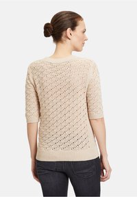 Beige gestrickter Pullover mit strukturiertem Muster, Dreiviertelärmeln und geripptem Saum. Offene Maschenstruktur sorgt für Atmungsaktivität.