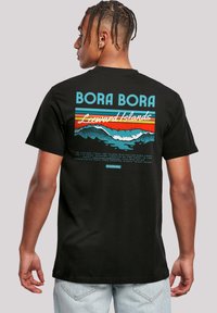Black cotton T-shirt featuring a colorful graphic print on the back, with "BORA BORA" text and wave motifs in turquoise, orange, and white.
