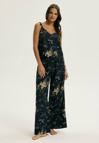 Granatowy komplet piżamowy ze złotymi wzorami niebiańskimi, obejmującymi chmury i mityczne stworzenia; dopasowany top na cienkich ramiączkach, spodnie o szerokich nogawkach.