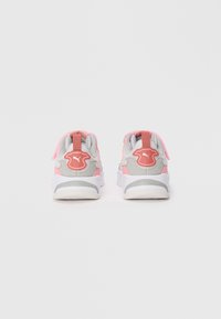 Baskets de sport grises et roses avec une texture lisse, arborant un logo bien visible, un col rembourré et des semelles blanches. Vue de dos montrant les détails du design.