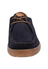 Chaussures lacées en suède bleu marine avec un bout rond, une couture visible, et une semelle en caoutchouc texturé brun clair. Lacets et accents marron.