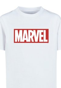 Balta medvilninė marškinėliai, turintys didelį raudoną stačiakampį grafiką su žodžiu "MARVEL" ryškiomis, baltomis didžiosiomis raidėmis. Lygi tekstūra.