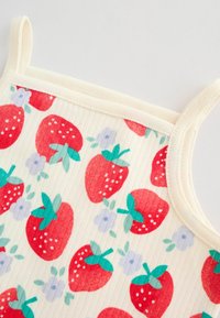 Kremowy prążkowany top na ramiączkach z nadrukiem czerwonych truskawek i drobnych jasnofioletowych kwiatów oraz cienkimi ramiączkami.