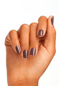 Hand met keurige manicuren, voorzien van een glanzende donkergrijs-brown nagellak. De hand is met de palm naar boven gepositioneerd, waarbij de gladde huid en gelijkmatige nagelvormen worden getoond.