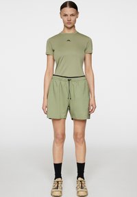 Olivgrön kortärmad skjorta med rund hals och logotyp; matchande lösa shorts med elastiskt midjeband och snörning.