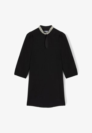 Abito nero con collo alto, maniche a tre quarti e dettaglio a goccia sul davanti. Collo impreziosito da perline. Tessuto liscio.