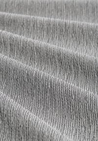 Tejido texturizado en tonos de gris, con finas rayas verticales; superficie suave y lisa con un ligero brillo, creando profundidad e interés visual.