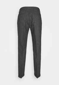 Pantalon formel gris foncé sur mesure avec poches arrière, passants de ceinture et coupe ajustée s'affinant vers les chevilles.