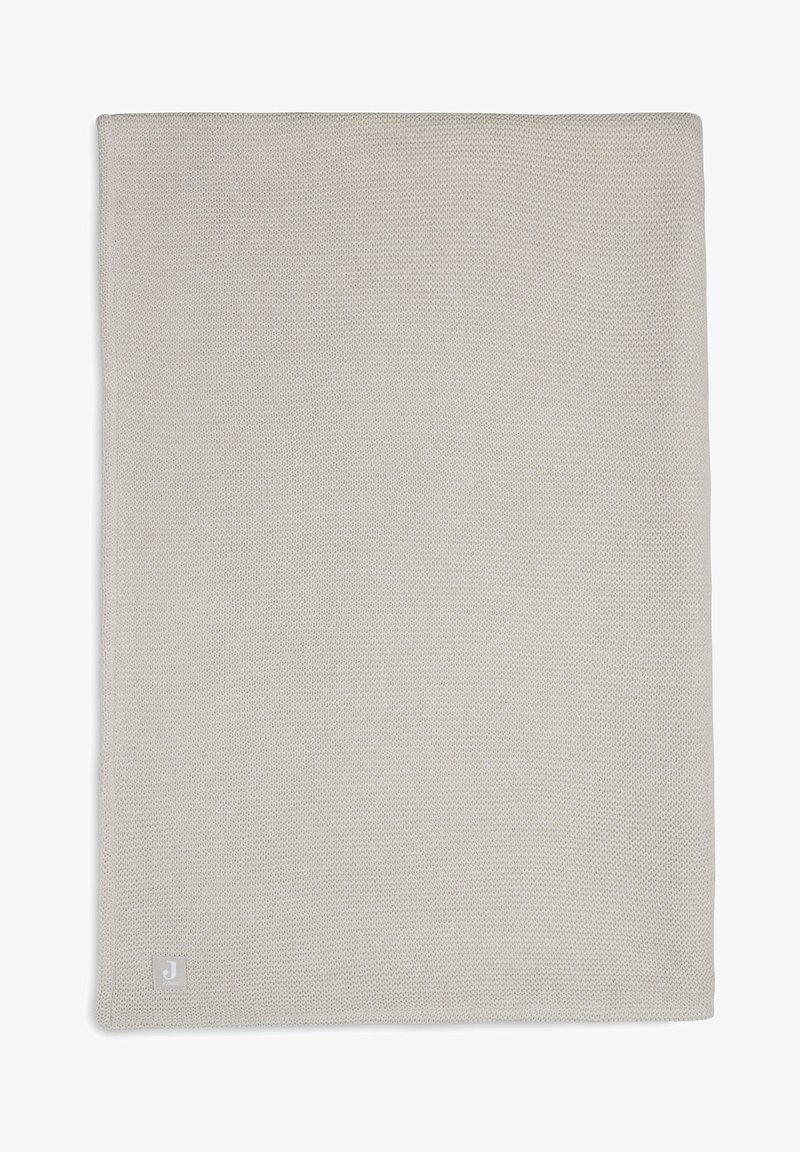 Lichtgrijze geweven deken met een gestructureerd oppervlak en een klein logo in de onderste hoek. Eenvoudige achtergrond voor een duidelijke weergave van het product.