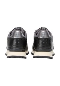 Sneaker sintetiche nere con accenti grigi. Forma arrotondata, collare imbottito e un logo distintivo sul tallone. Suola intermedia bianca con suola esterna nera testurizzata.