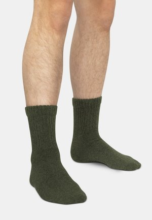 Green cotton socks with a ribbed design, featuring a crew length and a soft texture. The fabric appears thick and warm.