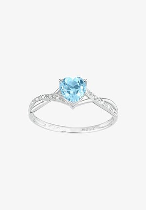 Hõbedane sõrmus, mille keskmes on südamekujuline helesinist värvi kalliskivi, mida kaunistavad väiksed selged kivid pöörleva disainiga sõrmuse külgedel.