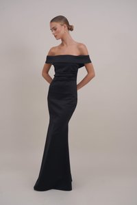 Musta olkaimeton gaalaasu, jossa on tiukka vartalo ja levenevä helma. Valmistettu sileästä kankaasta, jossa on minimaalinen tekstuuri. Yksinkertainen, elegantti muotoilu.