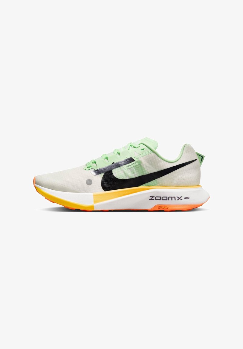 Chaussure de course Nike vert clair et blanc avec le logo Swoosh noir, semelle ZoomX jaune et orange, et semelle extérieure Vibram, vue de côté sur fond blanc.