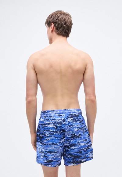 Μαγιό βερμούδα με μπλε κυματιστό σχέδιο, διαθέτει ελαστική μέση και πίσω τσέπη. Υφασμάτινο με υφή, ελαφρύ για άνεση και ευκινησία.