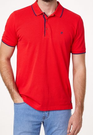 Camiseta polo roja con cuello, con detalles en azul marino en el cuello y las mangas. Hecha de algodón, con dos botones en el escote.