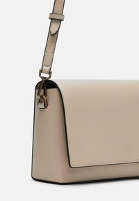 Borsa a mano in pelle beige con forma strutturata, tracolla regolabile e hardware in tonalità oro. Presenta impunture in contrasto e una chiusura a patta magnetica.