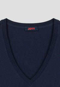 Camiseta azul marino con escote en V y una pequeña etiqueta negra en el cuello que dice "JOTT" en letras rojas.