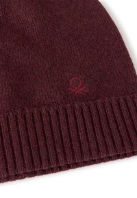 Beanie in magenta a maglia con orlo a coste, realizzato in tessuto morbido. Presenta un piccolo logo vicino all'orlo, aggiungendo un dettaglio discreto al design.