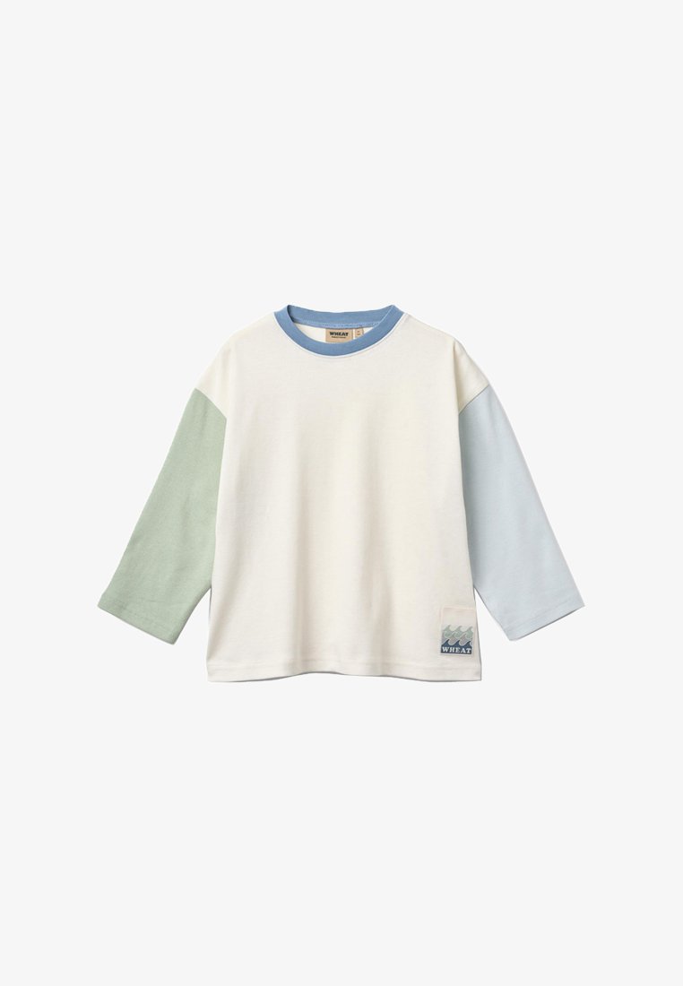 Peuterhemd met lange mouwen, met een crèmekleurig lichaam, groene linker mouw, lichtblauwe rechter mouw, blauwe kraag en een klein golfgrafiekapplicatie op de voorzoom.