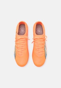 Felle oranje hardloopschoenen met een gestructureerde afwerking, voorzien van een blauw-wit ontwerp aan de zijkant en een standaard vetersluiting.