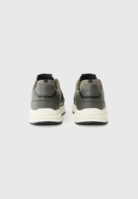 Green and black athletic shoes featuring a cushioned sole, textile and synthetic upper, and embossed logo at the heel.