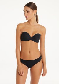 Černý bikiny top bez ramínek s hladkým, tvarovaným designem a odpovídajícími nízkými kalhotkami. Vyrobeno z měkkého, elastického materiálu.