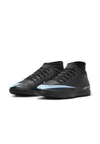Black soccer shoes with a high collar, textured upper, black laces, and a light blue Nike swoosh. Features a rubber sole for traction.