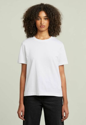 T-shirt en coton blanc avec un col rond et des manches courtes. Design à coupe droite, texture lisse et style minimaliste.