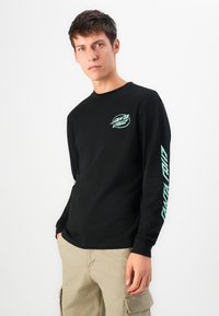 Zwarte lange mouwen T-shirt met een mintgroen logo op de borst en grafische tekst langs de mouw; gemaakt van katoen met een soepele textuur.