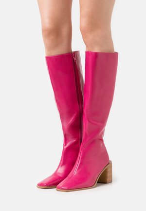Knee-high, shiny pink leather boots with a square toe and chunky heel. Features a side zipper and a smooth texture.