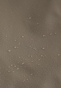 Des gouttes d'eau de différentes tailles dispersées sur une surface brune lisse créant une texture humide et réfléchissante.