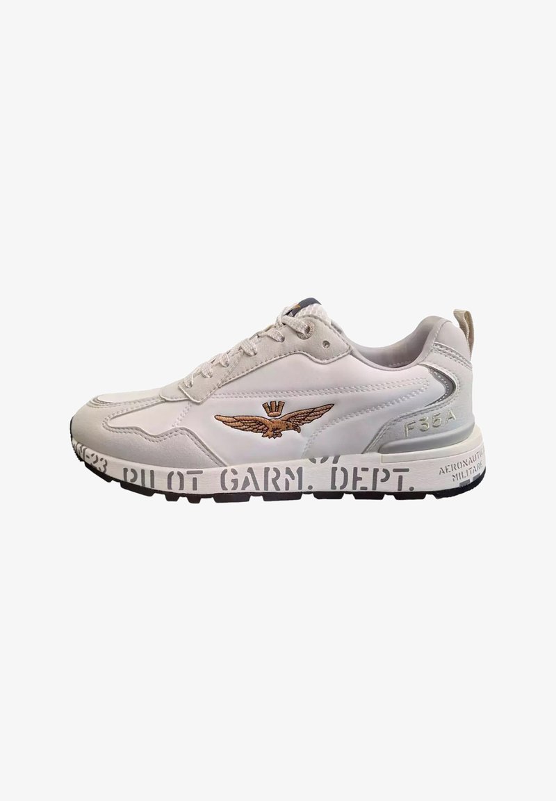 Sneaker bianco realizzato in materiali in pelle e rete, con un logo ricamato a forma di ala, suola nera e testo stampato sul lato.