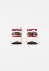 Rosa und beige Sneaker mit Akzenten im Leopardenmuster, Obermaterial aus strukturiertem Stoff und schwarzer Gummisohle. Schnürsenkel und Logodetail sind enthalten.
