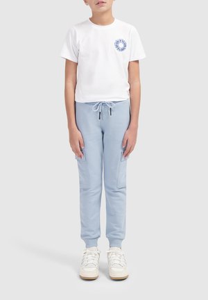 Witte T-shirt met korte mouwen met een blauwe grafische afbeelding op de borst, gecombineerd met lichtblauwe joggers met zijzakken en een koord in de taille.