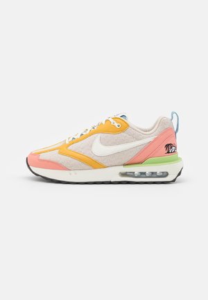 Baskets Nike Air Max en beige, orange, rose et vert avec un swoosh blanc, une semelle Air visible et un logo palmier au talon.