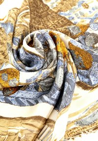 Pañuelo de seda con un diseño en espiral en azul, crema y marrón, adornado con intrincados patrones de árboles y monumentos. Textura suave y caída elegante.