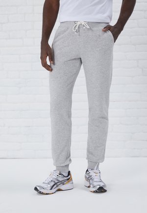 Grijze sweatpants van zacht materiaal, met een elastische tailleband met trekkoord en zijzakken. Tapered benen met ribgebreide boorden.