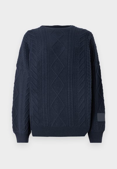 Navy blue knitted sweater with a textured cable pattern and crew neckline. Ribbed cuffs and hem, featuring a soft, thick material.