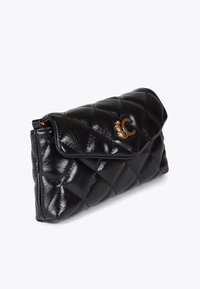 Borsa clutch in pelle nera trapuntata con chiusura a pattina. Presenta un emblema dorato e una texture liscia, evidenziando la cucitura a motivo a diamante.